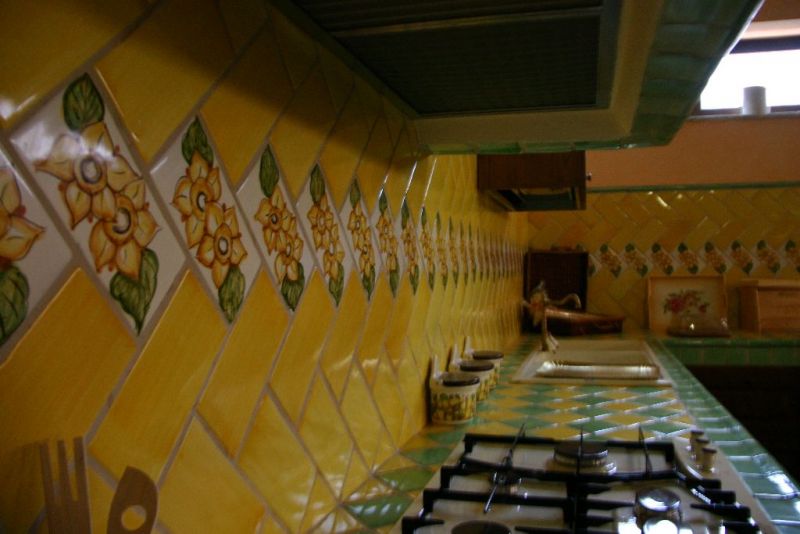 Cucina in terracotta e piastrelle decorate by Antica Fornace Caudina